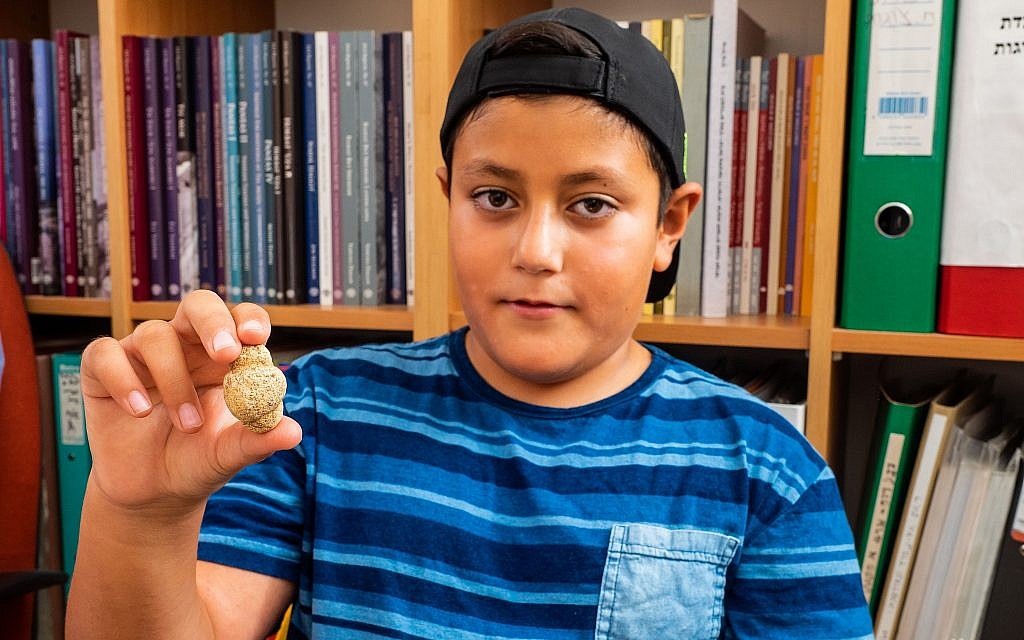 Itamar Barnea, 10, with an 11,500-year-old fertility figurine he found in the Upper Galilee in 2016. Photo taken in August 2018. (Assaf Peretz/Israel Antiquities Authority) Itamar Barnea, 10, with an 11,500-year-old fertility figurine he found in the Upper Galilee in 2016. Photo taken in August 2018. (Assaf Peretz/Israel Antiquities Authority)