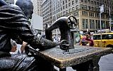 Tourists take photos at "The Garment Worker," a bronze sculpture of a garment worker wearing a yarmulke by Judith Weller at the edge of New York's Garment District, August 1, 2018. (AP Photo/Bebeto Matthews)