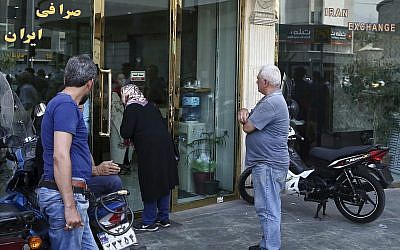 People wait in front of a closed money exchange shop for it to open, in downtown Tehran, Iran,  August 7, 2018. (AP/Ebrahim Noroozi)