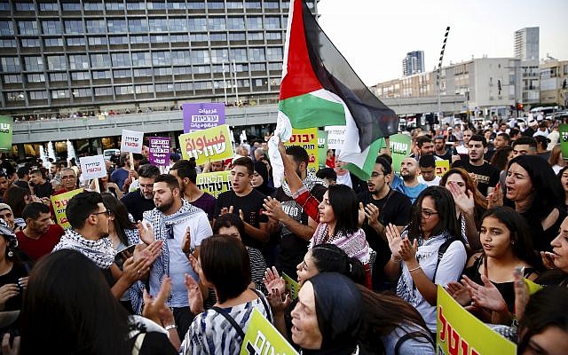Israeli Arabs hold a Palestinian flag during a protest against the Jewish nation bill in Tel Aviv, Israel, Saturday, Aug. 11, 2018. (AP/Ariel Schalit)