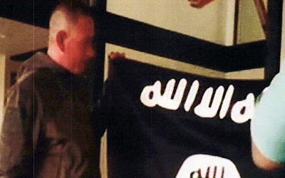 In this July 8, 2017 file image taken from FBI video and provided by the U.S. Attorney's Office in Hawaii on July 13, 2017, Army Sgt. 1st Class Ikaika Kang holds an Islamic State group flag after allegedly pledging allegiance to the terror group at a house in Honolulu.(FBI/U.S Attorney's Office, District of Hawaii via AP, File)
