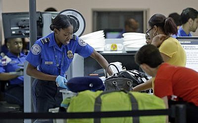 A Transportation Security Administration officer checks travelers luggage to be screened by an x-ray machine at a checkpoint at Fort Lauderdale-Hollywood International Airport, Friday, May 27, 2016, in Fort Lauderdale, Fla. (AP Photo/Alan Diaz)