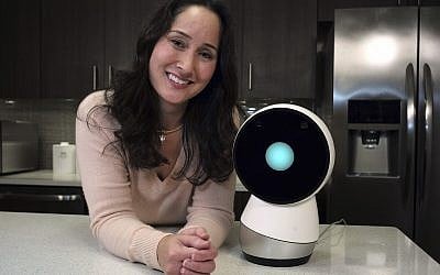 In this November 21, 2017, photo Massachusetts Institute of Technology robotics researcher Cynthia Breazeal, left, stands next to social robot Jibo, right, at the company's headquarters in Boston. (AP Photo/Steven Senne)