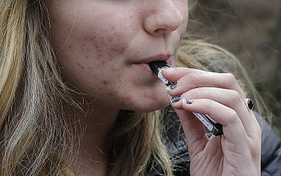 Illustrative: An unidentified 15-year-old high school student uses a vaping device (AP Photo/Steven Senne)