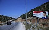 In this July 20, 2018, photo, a poster of President Bashar Assad with Arabic that reads "Welcome in victorious Syria." is seen on the border between Lebanon and Syria. (AP Photo/Hassan Ammar)