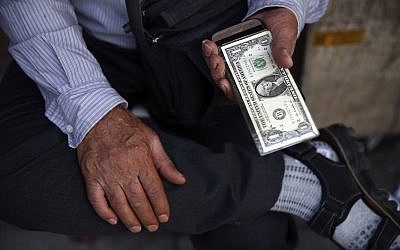 An Iranian street money exchanger holds US banknote in downtown Tehran, Iran, July 30, 2018 (AP Photo/Vahid Salemi)