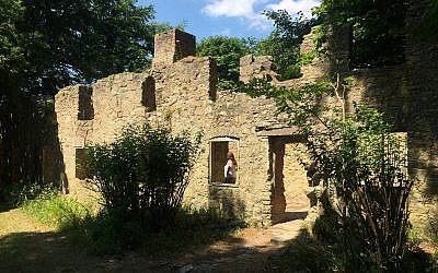 A visitor inspects the interior of a ruined cottage in the abandoned village of Tyneham, in Dorset, England, July 8, 2018. (Jerry Harmer/AP)