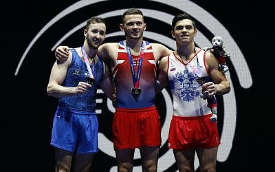 Dominick Cunningham of Great Britain, center, celebrates after winning gold in the floor exercise during the men's artistic gymnastics finals at the European Championships in Glasgow, Scotland, August 12, 2018. At left is Artem Dolgopyat of Israel who won silver and right is Artur Dalaloyan of Russia who won bronze. (AP Photo/Darko Bandic)