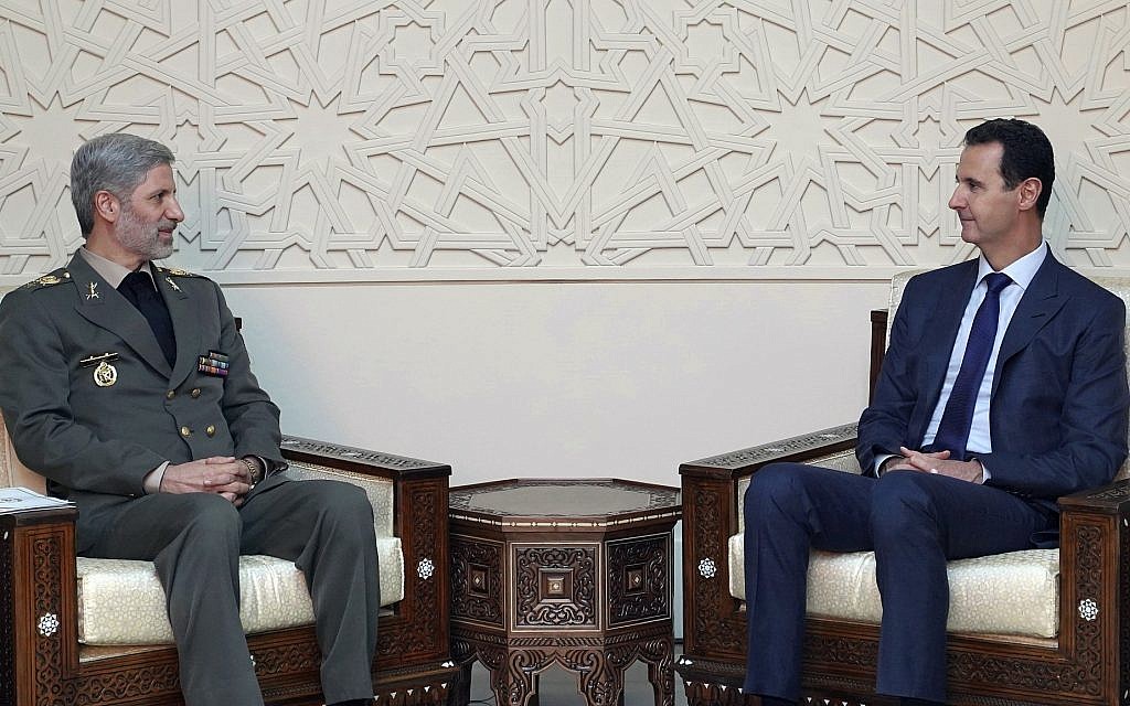 This photo released by the Syrian official news agency SANA, shows Syrian president Bashar Assad, right, meeting with Iran's Defense Minister Amir Hatami, in Damascus, Syria, Sunday, Aug. 26, 2018. (SANA via AP)