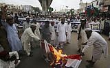 Pakistani protesters burn representation of Dutch flags during a protest to condemn the planned anti-Islam cartoon contest, in Karachi, Pakistan, on August 30, 2018. (AP/Fareed Khan)