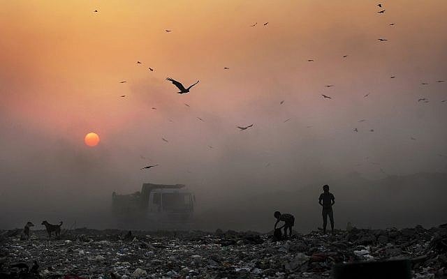 FILE- In this Oct. 17, 2014, file photo, a thick blanket of smoke is seen against the setting sun as young ragpickers search for reusable material at a garbage dump in New Delhi, India (AP Photo/Altaf Qadri, File) FILE- In this Oct. 17, 2014, file photo, a thick blanket of smoke is seen against the setting sun as young ragpickers search for reusable material at a garbage dump in New Delhi, India (AP Photo/Altaf Qadri, File)