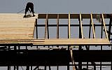Illustrative: A worker on a rooftop at a construction site in Jerusalem, August 5, 2015 (Nati Shohat/Flash90)