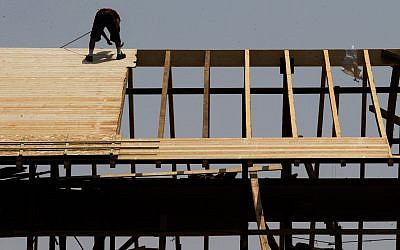 Illustrative: A worker on a rooftop at a construction site in Jerusalem, August 5, 2015 (Nati Shohat/Flash90)
