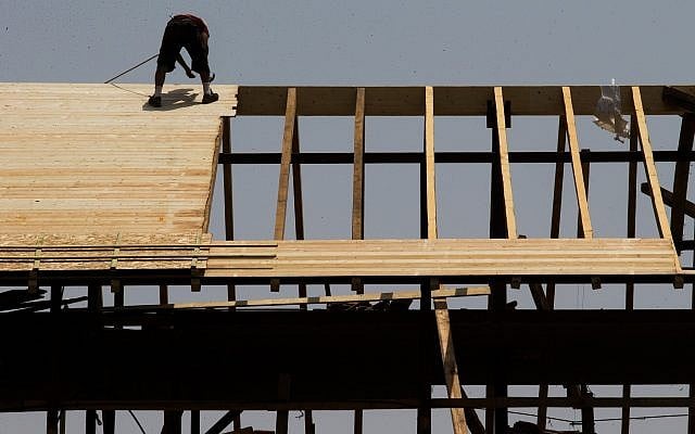 Illustrative: A worker on a rooftop at a construction site in Jerusalem, August 5, 2015 (Nati Shohat/Flash90) Illustrative: A worker on a rooftop at a construction site in Jerusalem, August 5, 2015 (Nati Shohat/Flash90)