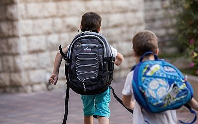 Illustrative: Israeli kids wearing school bags for first day of school outside their home in Jerusalem (Yonatan Sindel/Flash90)
