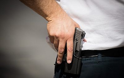 An illustration of a man holding a pistol on July 14, 2017. (Yonatan Sindel/Flash90)