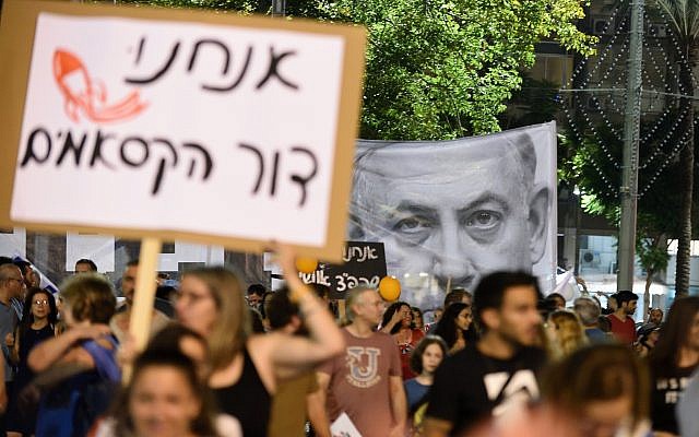 Demonstrators hold up signs at a Tel Aviv rally demanding security for residents of Israel's south on August 18, 2018. (Gili Yaari/Flash90)