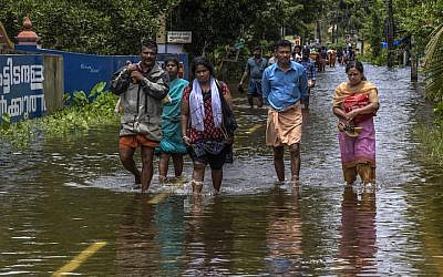 Locals cross flood water en route to  Chengannur on August 20, 2018 in Kerala, India. (Atul Loke/Getty Images/via JTA)