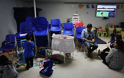 Recently arrived migrant families speak with volunteers at the Catholic Charities Humanitarian Respite Center on June 21, 2018 in McAllen, Texas. (Spencer Platt/Getty Images/via JTA)