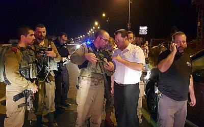 Samaria Regional Council Chairman Yossi Dagan (2nd right) speaks with a soldier at the scene where an Israeli woman was run over and killed by a Palestinian driver, near the northern West Bank settlement outpost of Havat Gilad on August 16, 2018. (Roi Hadi/Samaria Regional Council)