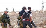 An injured left-wing activist being escorted by IDF soldiers, near the West Bank settlement of Mitzpeh Yair, August 25, 2018. (B'Tselem)