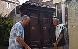 Tom Furstenberg, right, and a fellow congregant carrying the Torah ark out of the Great Synagogue of Deventer, July 30, 2018. (Cnaan Liphshiz)