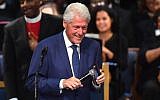 Former US President Bill Clinton plays an Aretha Franklin song on his phone during Franklin's funeral at Greater Grace Temple on August 31, 2018 in Detroit, Michigan. (AFP PHOTO / Angela Weiss)