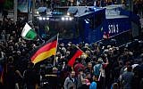 Illustrative: Demonstrators crowd around a water cannon of the police during a protest organised by the right-wing populist 'Pro Chemnitz' movement, the far-right Alternative for Germany (AfD) party and the anti-Islam Pegida movement, on September 1, 2018 in Chemnitz, eastern Germany. (AFP/John MacDougall)
