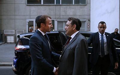President of the Central Jewish Consistory of Paris Joel Mergui (C) greets French President Emmanuel Macron (L) upon his arrival to attend a ceremony to mark the Jewish New Year - Rosh Hashanah - at The Great Synagogue in Paris on September 4, 2018. (AFP PHOTO / POOL / YOAN VALAT)