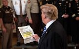 US President Donald Trump reads from an article praising his administration as he answers a journalist during a meeting with sheriffs at the White House in Washington, DC, on September 5, 2018.
Trump was responding to an anonymous "senior official" who wrote an op-ed article entitled "I Am Part of the Resistance Inside the Trump Administration" in The New York Times on September 5. (AFP PHOTO / NICHOLAS KAMM)