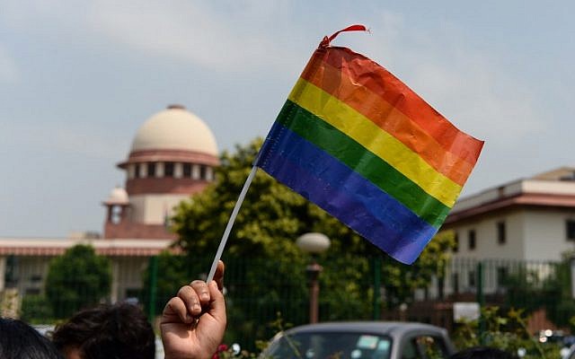 An Indian member of the lesbian, gay, bisexual, transgender (LGBT) community waves a flag outside the Supreme Court building as crowds gathered to celebrate the decision to strike down the colonial-era ban on gay sex in New Delhi on September 6, 2018. (AFP PHOTO / SAJJAD HUSSAIN) An Indian member of the lesbian, gay, bisexual, transgender (LGBT) community waves a flag outside the Supreme Court building as crowds gathered to celebrate the decision to strike down the colonial-era ban on gay sex in New Delhi on September 6, 2018. (AFP PHOTO / SAJJAD HUSSAIN)