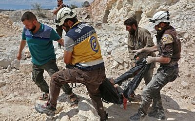 Members of the Syrian Civil Defense, also known as the 'White Helmets,' carrying a victim after airstrikes in Kafr Ain in the Idlib province, September 7, 2018. (AFP/Anas al-Dyab)