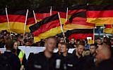 People hold national flags during a march organized by the right-wing populist 'Pro Chemnitz' movement on September 7, 2018 (AFP PHOTO / John MACDOUGALL)