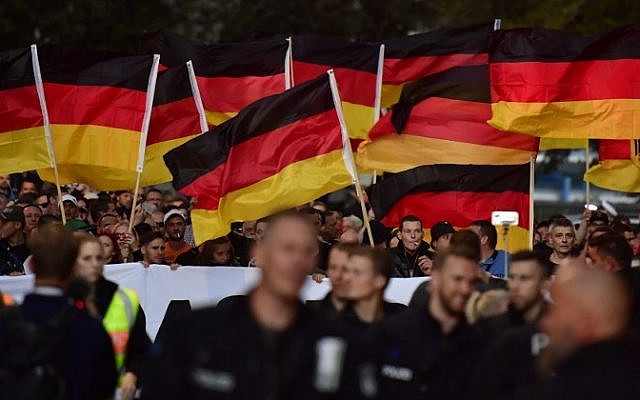 People hold national flags during a march organized by the right-wing populist 'Pro Chemnitz' movement on September 7, 2018 (AFP PHOTO / John MACDOUGALL) People hold national flags during a march organized by the right-wing populist 'Pro Chemnitz' movement on September 7, 2018 (AFP PHOTO / John MACDOUGALL)