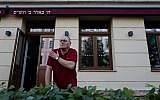 Uwe Dziuballa, owner of the Schalom restaurant in Chemnitz, eastern Germany, describes to a journalist on September 8, 2018, how he was hit in the shoulder with a rock when his Jewish restaurant was attacked by a group of masked men on August 27, 2018. (AFP Photo/John MacDougall)