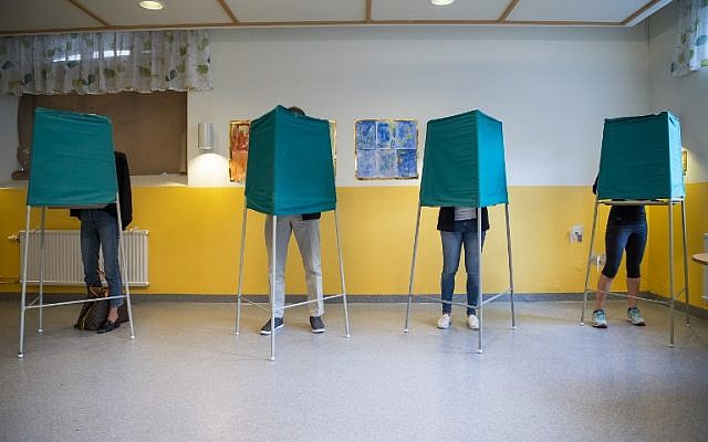People stand on booths at a polling station during the Swedish general elections in Stockholm on September 9, 2018. (AFP Photo/Jonathan Nackstrand)
