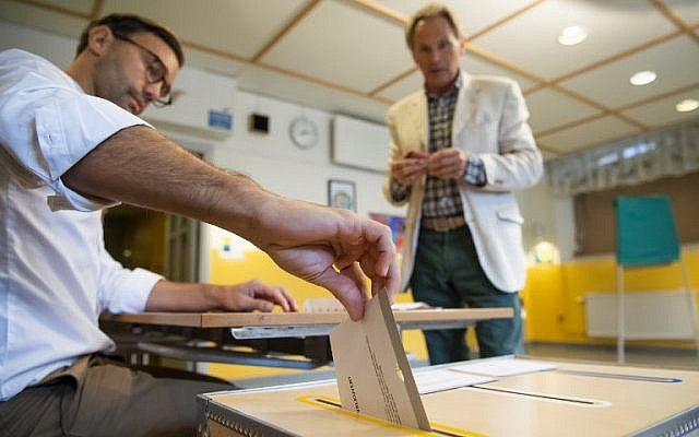 An election official casts a voter's ballot at a polling station during the Swedish general elections in Stockholm on September 9, 2018. (AFP Photo/Jonathan Nackstrand) An election official casts a voter's ballot at a polling station during the Swedish general elections in Stockholm on September 9, 2018. (AFP Photo/Jonathan Nackstrand)