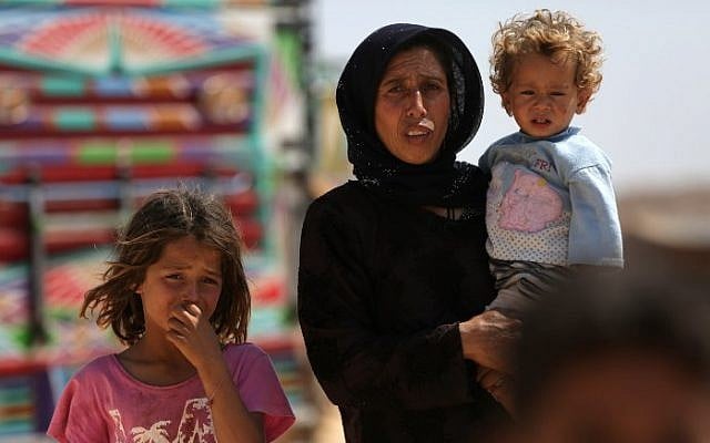 A woman who fled her village in Syria's Idlib province carries a child at a camp in Kafr Lusin near the border with Turkey in the northern part of the province on September 9, 2018. (AFP PHOTO / Aref Tammawi) A woman who fled her village in Syria's Idlib province carries a child at a camp in Kafr Lusin near the border with Turkey in the northern part of the province on September 9, 2018. (AFP PHOTO / Aref Tammawi)