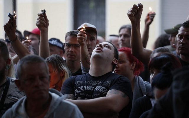 People with lighters are pictured after a march in Koethen, eastern Germany, on September 9, 2018. (AFP Photo/Odd Andersen) People with lighters are pictured after a march in Koethen, eastern Germany, on September 9, 2018. (AFP Photo/Odd Andersen)
