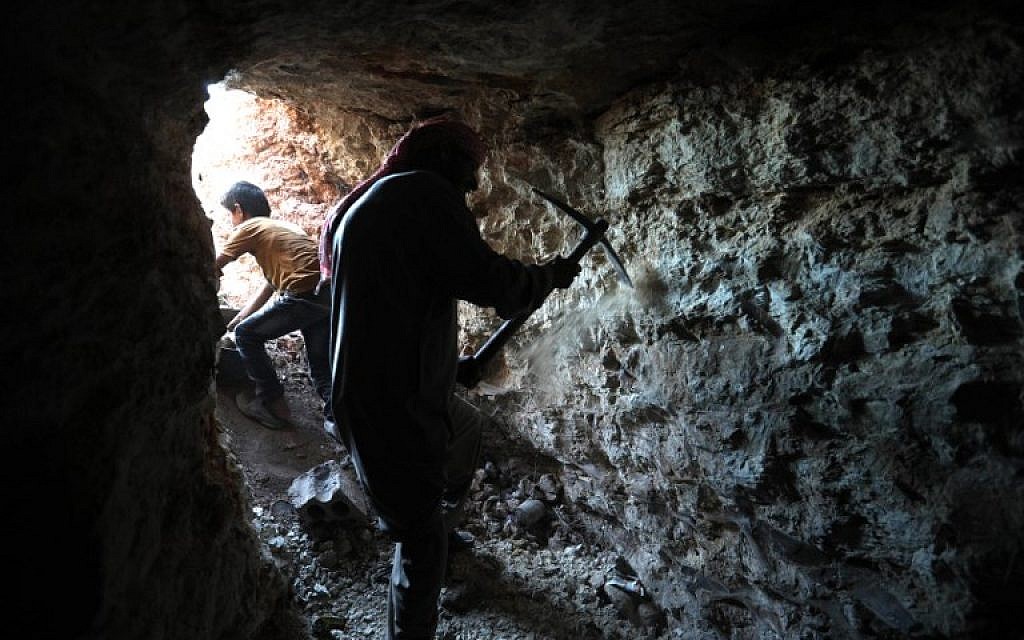 A man uses a pickaxe to dig a cave in the Syrian village of Kafr Ain in the southern countryside of the rebel-held Idlib province on September 15, 2018. (AFP /OMAR HAJ KADOUR) A man uses a pickaxe to dig a cave in the Syrian village of Kafr Ain in the southern countryside of the rebel-held Idlib province on September 15, 2018. (AFP /OMAR HAJ KADOUR)