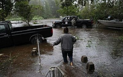 A resident walks from her flooded house towards the crew of the Cajun Navy in Lumberton, North Carolina, on September 15, 2018 in the wake of Hurricane Florence. 
(AFP /Alex EDELMAN)
