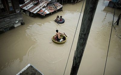 Children use basins to cross a flooded street in the aftermath of Super Typhoon Mangkhut at Salonga Compound in Calumpit, Bulacan, on September 16, 2018. (AFP PHOTO / NOEL CELIS)