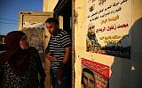 Neighbours of 24-year-old Palestinian Muhammad Zaghloul Khatib look at his poster in the West Bank village of Bayt Rima, north of Ramallah, on September 18, 2018. (AFP Photo/Abbas Momani)