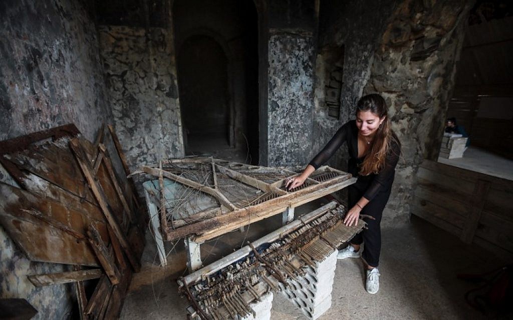 This picture taken on September 21, 2018, shows a woman touching the remains of a destroyed piano in a room at the Sofar Grand Hotel in the Lebanese village of Sofar, some 30 kilometers (20 miles) east of Beirut. (AFP PHOTO / ANWAR AMRO) This picture taken on September 21, 2018, shows a woman touching the remains of a destroyed piano in a room at the Sofar Grand Hotel in the Lebanese village of Sofar, some 30 kilometers (20 miles) east of Beirut. (AFP PHOTO / ANWAR AMRO)