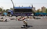 This picture taken on September 22, 2018, in the southwestern Iranian city of Ahvaz shows injured soldiers lying on the ground at the scene of an attack on a military parade marking the anniversary of the outbreak of its devastating 1980-1988 war with Saddam Hussein's Iraq. (AFP/ISNA/Alireza Mohammadi)