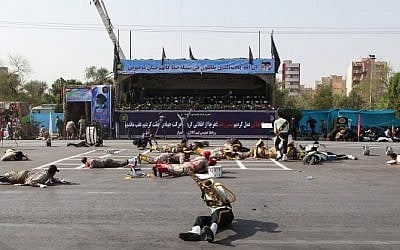 This picture taken on September 22, 2018, in the southwestern Iranian city of Ahvaz shows injured soldiers lying on the ground at the scene of an attack on a military parade marking the anniversary of the outbreak of its devastating 1980-1988 war with Saddam Hussein's Iraq. (AFP/ISNA/Alireza Mohammadi)