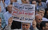 An Iranian man holds a placard denouncing the USA, Israel and Saudi Arabia during a mass funeral for the victims of those killed during an attack on a military parade on the weekend, in the southwestern Iranian city of Ahvaz on September 24, 2018. (AFP PHOTO / ATTA KENARE)
