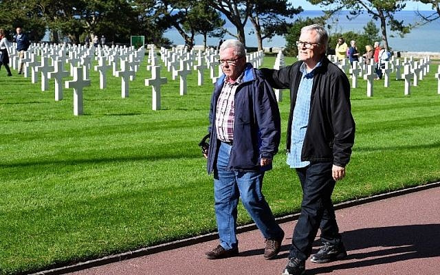Andre Gantois (L), 72, a resident of Ludres, in eastern France, and Allen Henderson, 65, of Greenville, South Carolina, walk past graves at the Normandy American Cemetery and Memorial on September 24, 2018, in Colleville-sur-Mer. (AFP PHOTO / Damien MEYER) Andre Gantois (L), 72, a resident of Ludres, in eastern France, and Allen Henderson, 65, of Greenville, South Carolina, walk past graves at the Normandy American Cemetery and Memorial on September 24, 2018, in Colleville-sur-Mer. (AFP PHOTO / Damien MEYER)