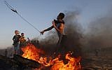 A Palestinian demonstrator uses a slingshot to throw stones during a protest on the Gaza-Israel border on September 24, 2018. (AFP PHOTO / SAID KHATIB)