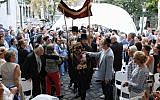 Rabbi Asher Faith carries a new Torah scroll being dedicated alongside the new congregation at the dedication of the prayer space in the Medieval Jewish Prayer House in Budapest, September 6, 2018. (Márton Merész)